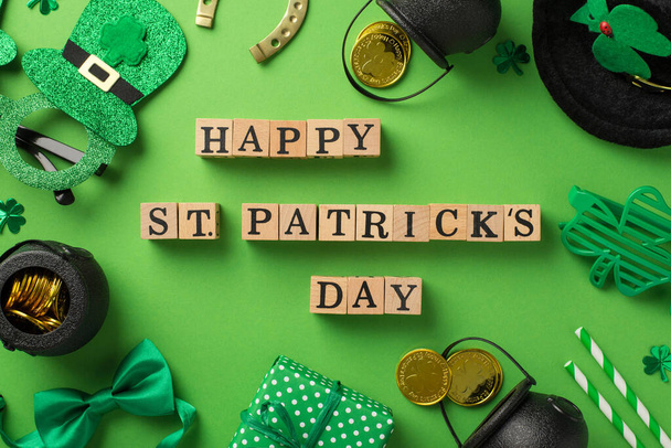 Top view photo of wooden cubes labeled happy st patricks day party glasses leprechaun hat straws green bow-tie giftbox horseshoe shamrocks and pots with gold coins on isolated pastel green background - Photo, image