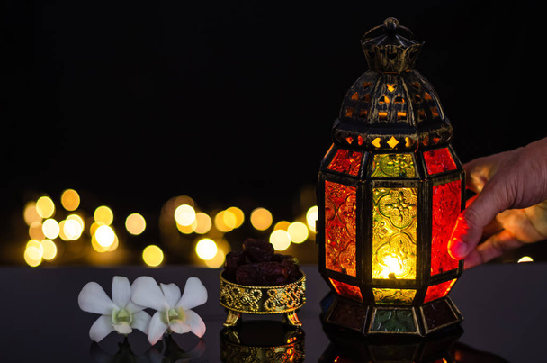Linterna y dátiles fruta con flor de orquídea blanca sobre fondo claro bokeh para la fiesta musulmana del mes santo de Ramadán Kareem. - Foto, imagen
