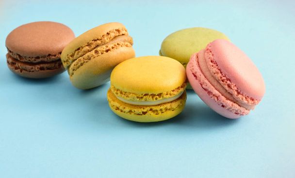 Macaroons, isolated on blue background, typical french sweet. - Photo, Image