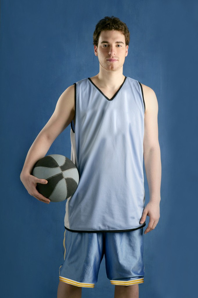 Basket player young man over blue - 写真・画像