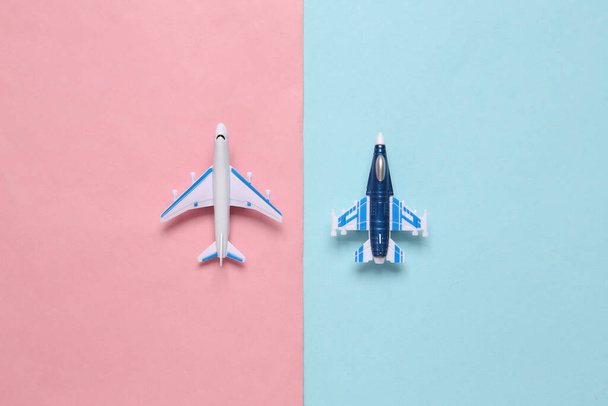 Militärische Kampfflugzeuge und Passagierflugzeuge auf einem blau-rosa Hintergrund. Spielzeugmodelle - Foto, Bild