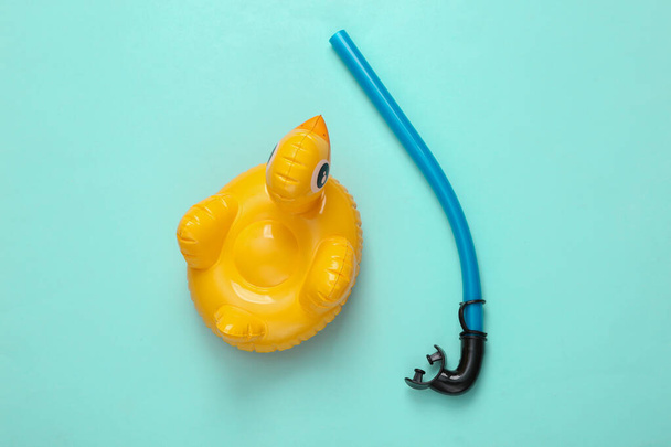Inflatable duck with snorkel on blue background. Minimal summer concept. Top view. - 写真・画像