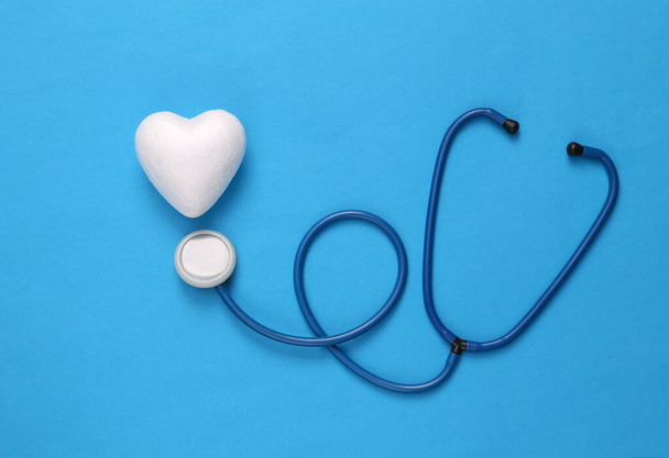 Sztsztetoszkóp kék hátterű szívekkel. Orvosság, szerelem koncepció - Fotó, kép