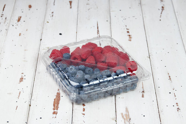 Boîtes en plastique de baies fraîches bio saines aux framboises, bleuets - Photo, image