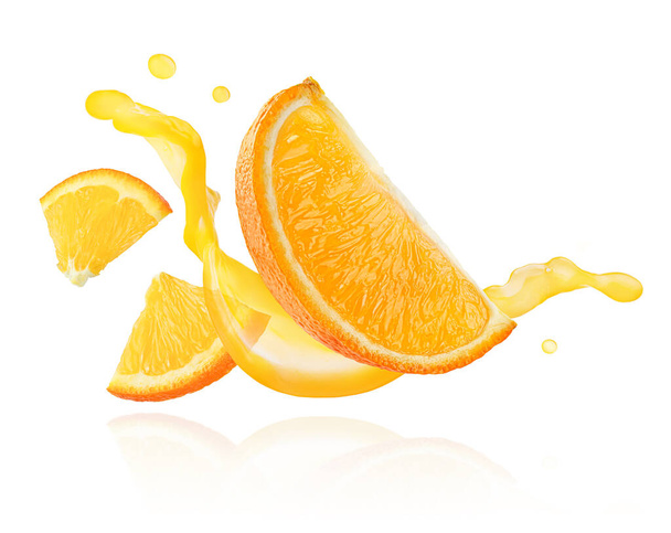 白い背景に隔離された汁の飛び散る波に浮かぶオレンジのスライス. - 写真・画像