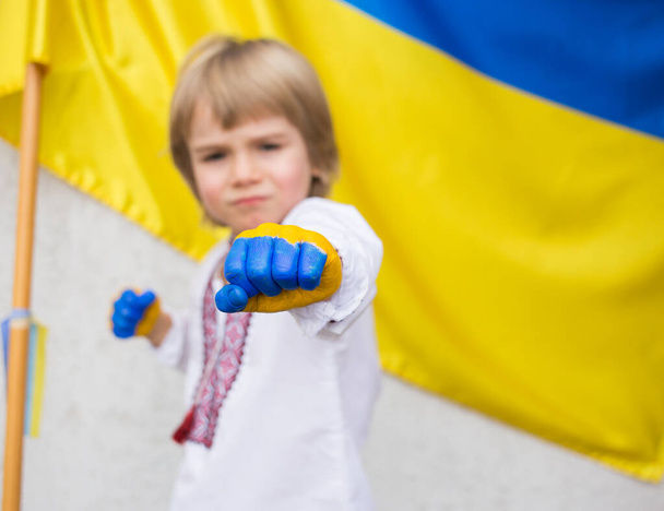 El a kezekkel Ukrajnától. gyerekek kezét festik a színek az ukrán zászló, egy ököl előterjesztett, a kérelmet, hogy hagyja abba a háborút Ukrajnában. nemzeti függetlenség. gyermekek háború ellen - Fotó, kép