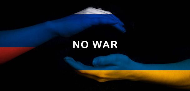 Rusia vs Ucrania bandera NINGUNA GUERRA concepto. Crisis, conflicto militar. Manos con banderas en foto negra - Foto, imagen