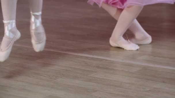 Baletní trénink - holčičky v růžových šatech skákají na místě - Záběry, video