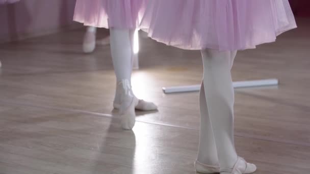 Baletní trénink - pět dívek v krásných šatech trénink u stánků ve studiu - stojící v pozici - Záběry, video