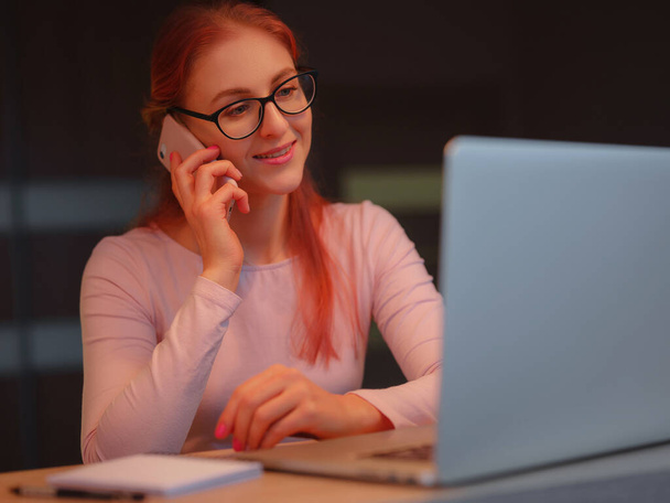 miellyttävä onnellinen nuori nainen freelancer työskentelee tietokoneella kotona. Houkutteleva nainen opiskelee verkossa kannettavan tietokoneen ohjelmiston, web surfing tietoa tai verkkokaupoissa. - Valokuva, kuva