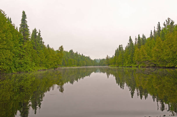 Aguas tranquilas en un lago nublado en Cliff Lake en las aguas fronterizas en Minnesota - Foto, Imagen