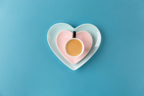 Xícara de café na placa em forma de coração no fundo azul. Vista superior, espaço de cópia. - Foto, Imagem