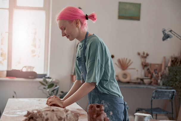 Female master modeling clay piece in pottery room - 写真・画像