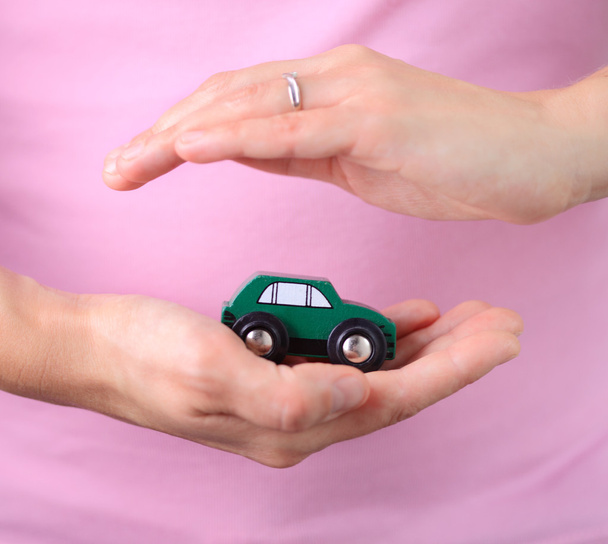 Nő a kezében tart, miniatűr autó - Fotó, kép