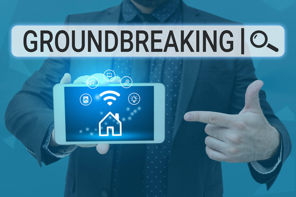 Text sign showing Ground Breaking. Business approach Very new and a big change from other things of its type Man holding Screen Of Mobile Phone Showing The Futuristic Technology. - Photo, Image