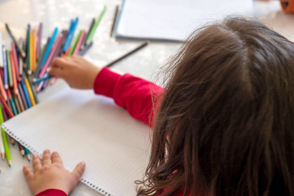 niña para colorear con lápices de colores en la mesa, primer plano de los niños del jardín de infantes para colorear, - Foto, imagen