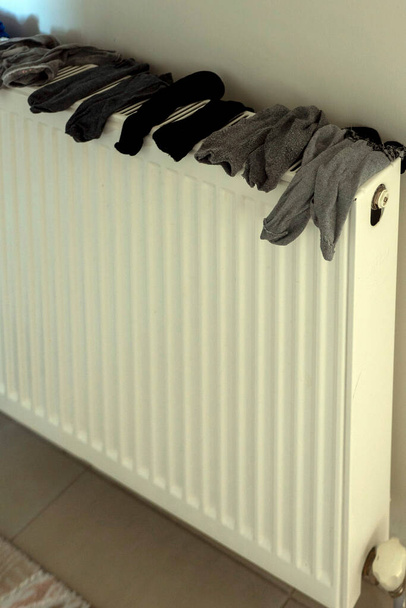 Πρακτικό στέγνωμα ρούχων στο σπίτι το χειμώνα, κάλτσες ξήρανση σε πυρήνες θέρμανσης, - Φωτογραφία, εικόνα