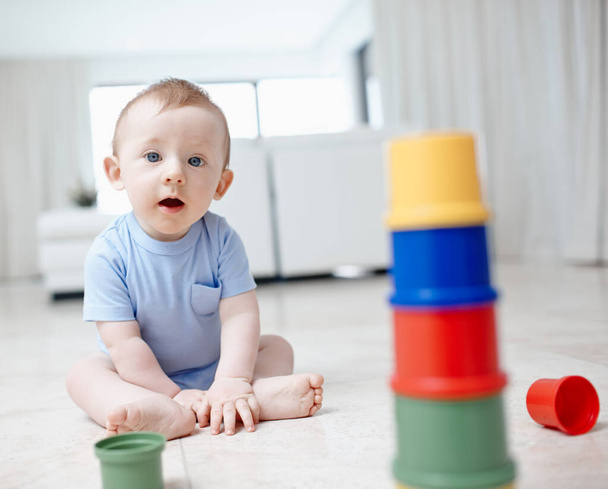 The building blocks to a bright mind. A playful baby boy sitting on the living room floor. - Photo, Image