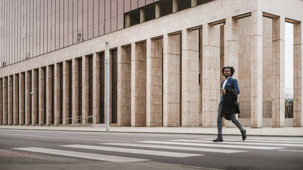 Великий довгий шматок молодого африканського бізнесмена переходити вулицю з щастям, місце для копіювання - Фото, зображення