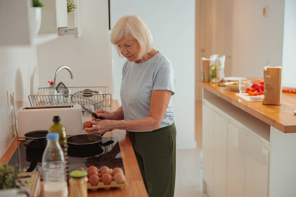 家庭で台所で調理する高齢女性 - 写真・画像