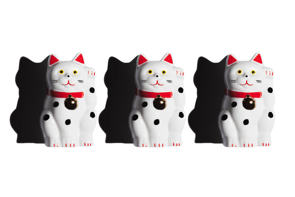 Tres gatos maneki-neko sobre un fondo blanco, dura sombra. - Foto, Imagen