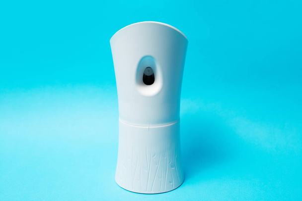 Close-up of automatic air freshener on blue background. - Фото, изображение
