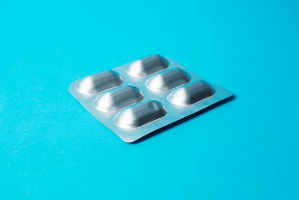 Close-up de blister com pílulas em fundo azul. - Foto, Imagem