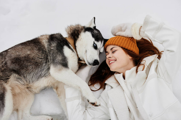 young woman in the snow playing with a dog fun friendship Lifestyle - Zdjęcie, obraz