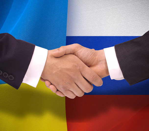 Χειραψία για την ειρήνη της Ρωσίας κατά της Ουκρανίας, φόντο των δύο σημαίες της Ουκρανίας και της Ρωσίας - Φωτογραφία, εικόνα