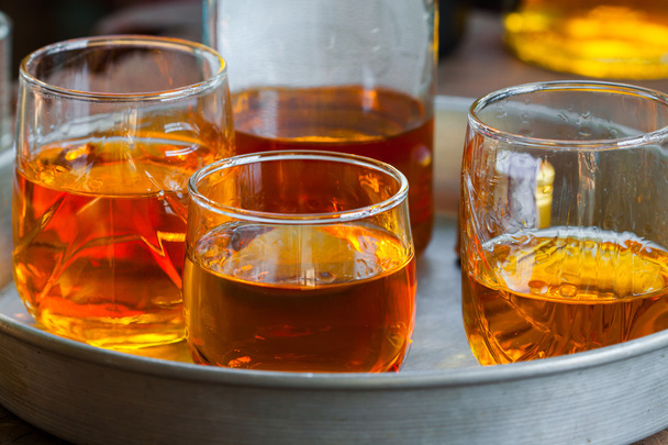 gouden bruin whisky op de rotsen in een glas - Foto, afbeelding