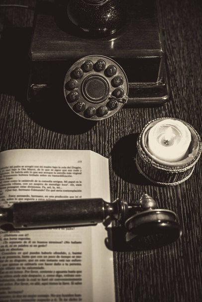 old phone on wooden table with book - 写真・画像