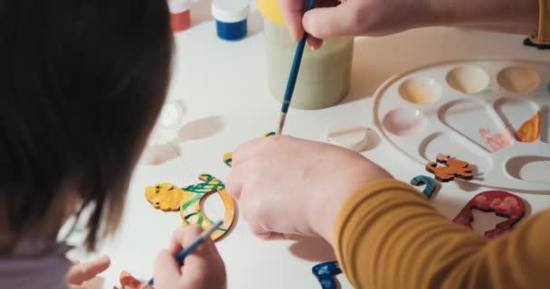 Kind met oma schildert zelfgemaakte kerstboom speelgoed gemaakt voor Kerstmis - Video