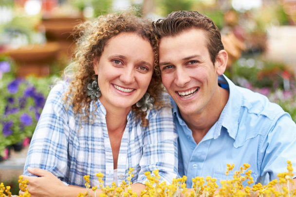 Adoramos jardinagem. Um casal feliz escolhendo flores em um berçário. - Foto, Imagem
