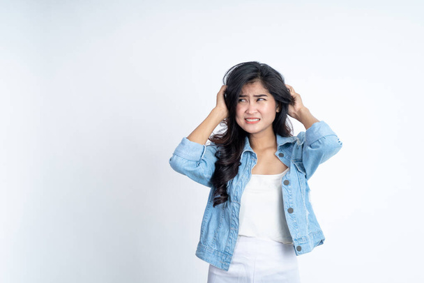Asian young woman holding head with headache on isolated background - Foto, imagen