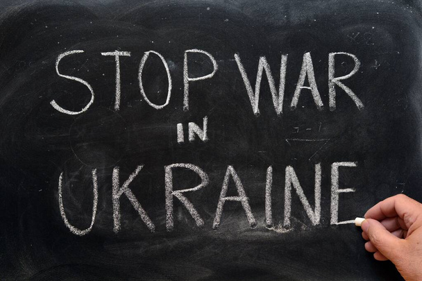 Stop oorlog in Oekraïne, met de hand geschreven met een krijt op het schoolbord - Foto, afbeelding