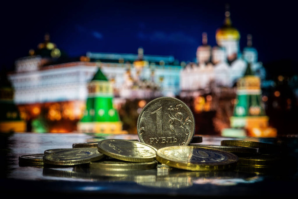 Moeda em denominação de 1 rublo russo em uma pilha de outras moedas na frente de fragmentos simbólicos fora de foco do Kremlin de Moscou - Foto, Imagem