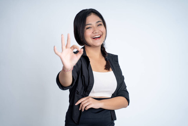 woman smiling with okay hand gesture on isolated background - Valokuva, kuva