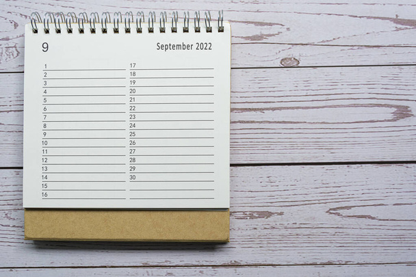 September planner en organisator 2022 kalender op houten bureau. Direct boven. Plat gelegd. Voor tekstdoeleinden. - Foto, afbeelding