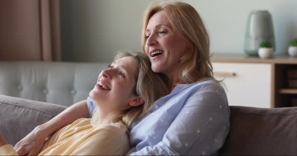 Young daughter her older mother relax on sofa enjoy conversation - Filmagem, Vídeo