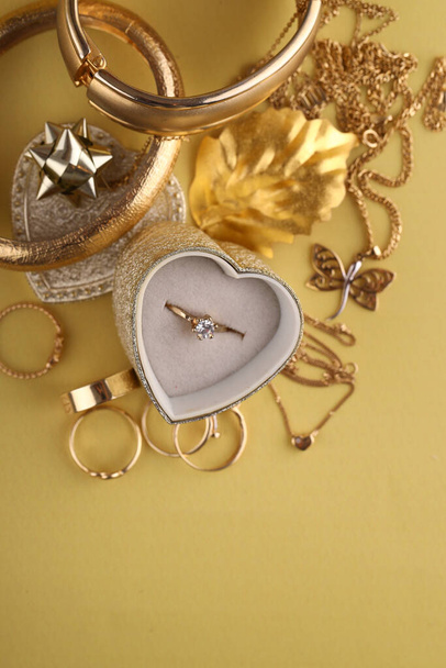 gouden sieraden, ringen op een gele achtergrond - Foto, afbeelding
