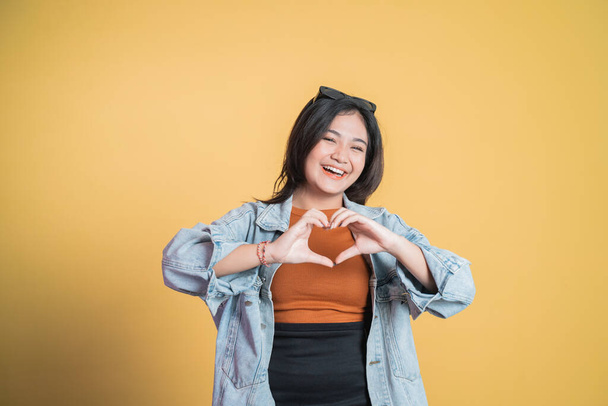 young woman laughing with heart shape with fingers - Фото, изображение