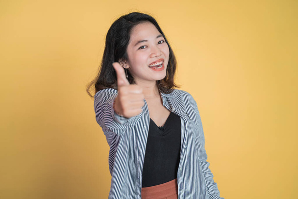 attractive young woman stand with thumbs up on isolated background - Foto, afbeelding