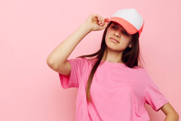 cheerful young girl with a cap on her head in a pink t-shirt - 写真・画像