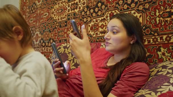 KriwojRog, UKRAINE - FEBRUAR 2022 Ein trauriges Mädchen betrachtet die schrecklichen Nachrichten auf dem Smartphone über die russische Offensive auf dem Territorium der Ukraine. Nachrichten über Spannungen zwischen der Ukraine und Russland - Filmmaterial, Video