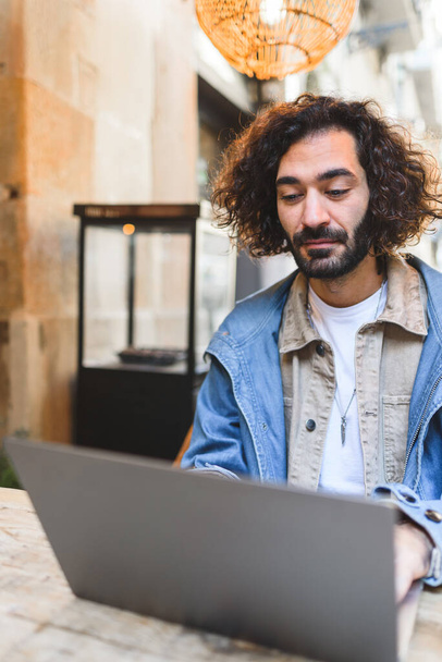 Spanyol férfi laptopot használ az utcai kávézóban. - Fotó, kép
