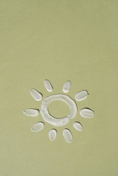 Güzellik ürünü. Güneş beyaz kozmetik krem lekesi, tarafsız yeşil arkaplanda leke - Fotoğraf, Görsel