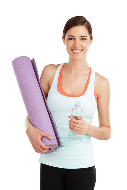 Be a no excuse kinda girl. Portrait of a beautiful young woman holding her exercise mat and a bottle of water. - Foto, afbeelding
