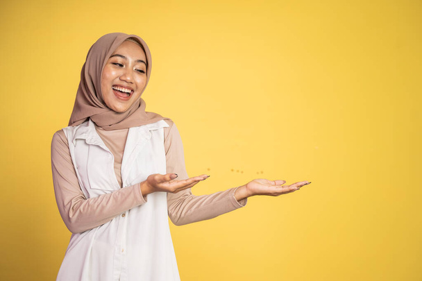 Young hijab woman with hand gesture presenting something - Zdjęcie, obraz