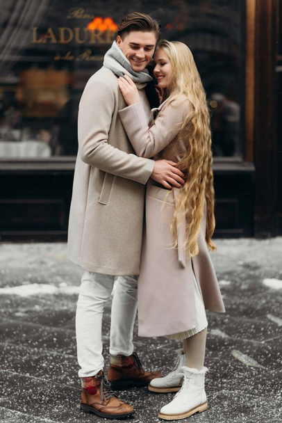 amor pareja amor abrigo beige gris blanco ramo de flores ternura sentimientos caminar abrazo fecha - Foto, Imagen