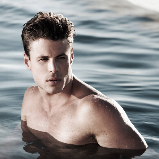 A moment to myself. A handsome male model in water looking to the side. - Fotó, kép